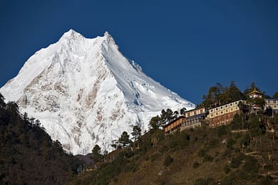 Buddhist monastery in front of peak of Manaslu - one of the highest mountains in the world.